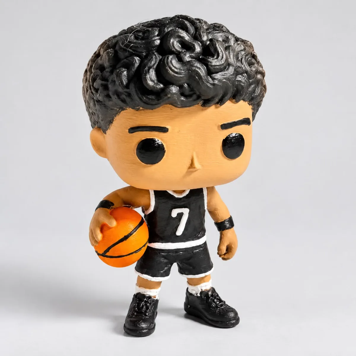 Boneco colecionável de cabelo cacheado com uniforme preto número 7 segurando uma bola de basquete