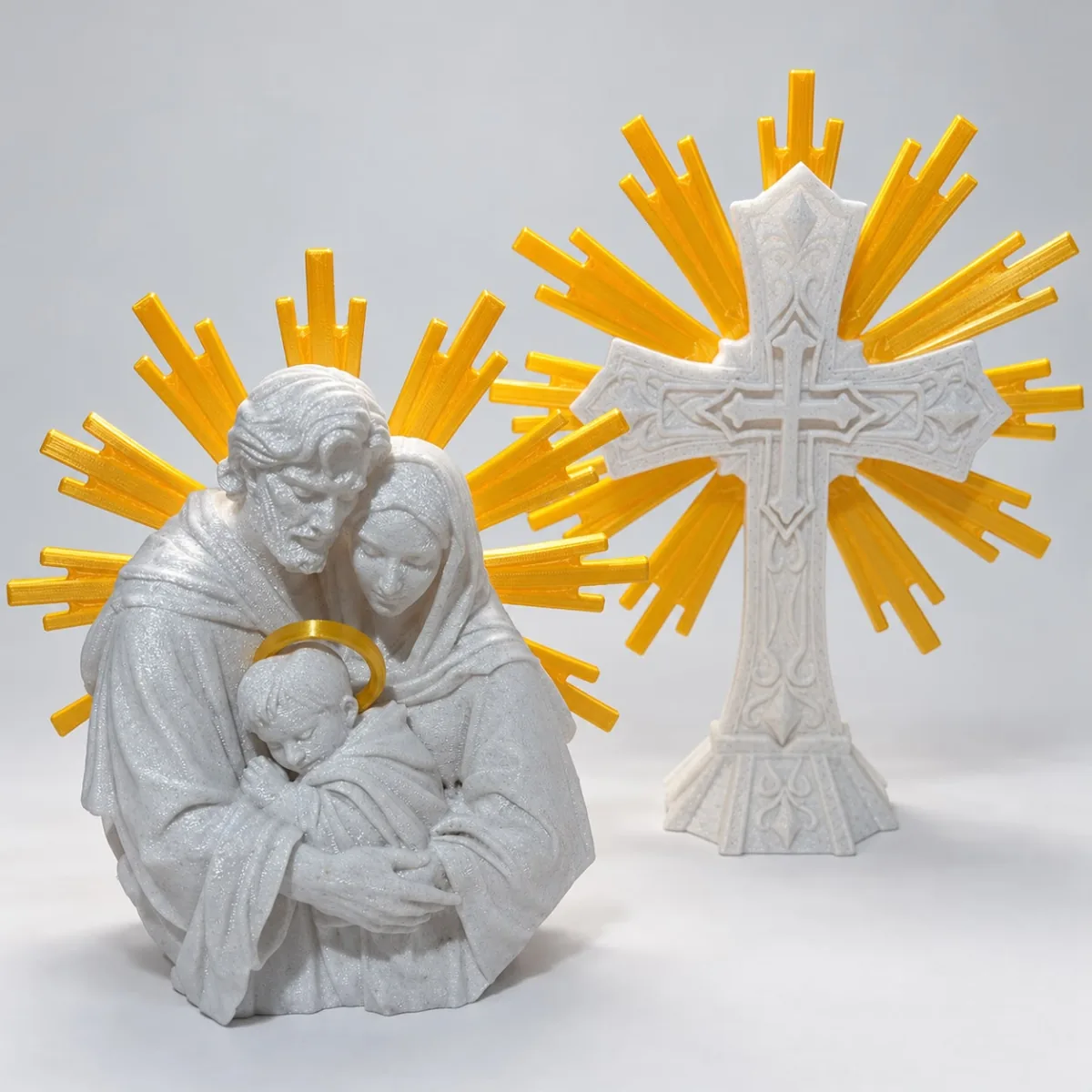 Imagem cinza da Sagrada Família e uma cruz branca, ambas com raios dourados ao fundo